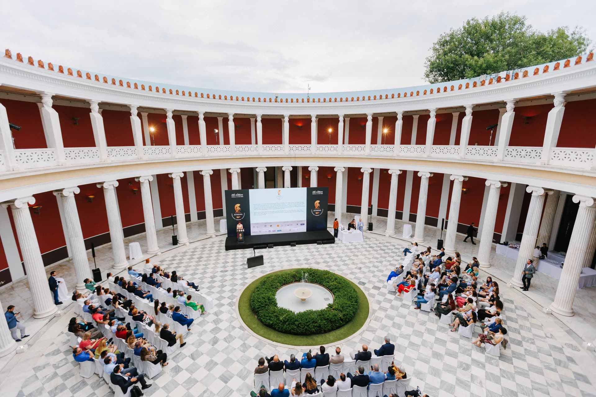ATHENA International Olive Oil Competition ceremony in a colonnaded courtyard